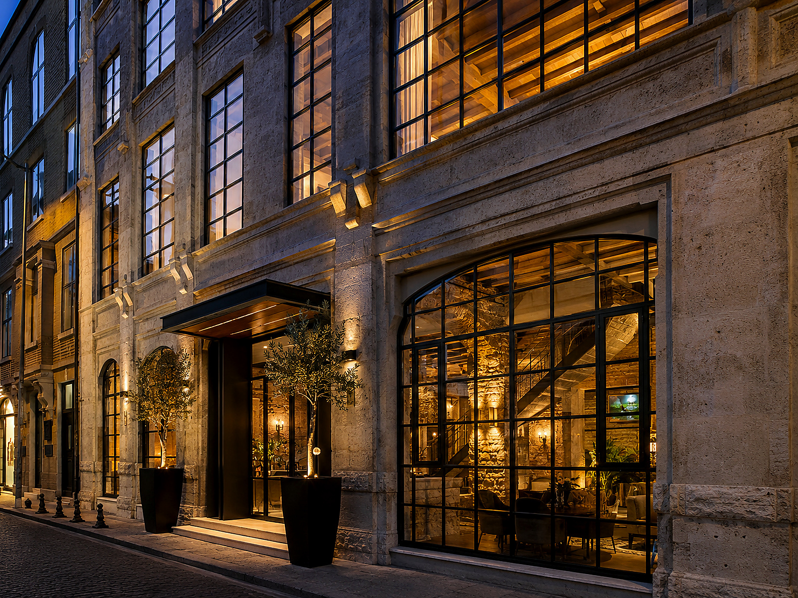 Akşam ışığında taş cepheli butik otel girişi ve dar Karaköy sokağı
