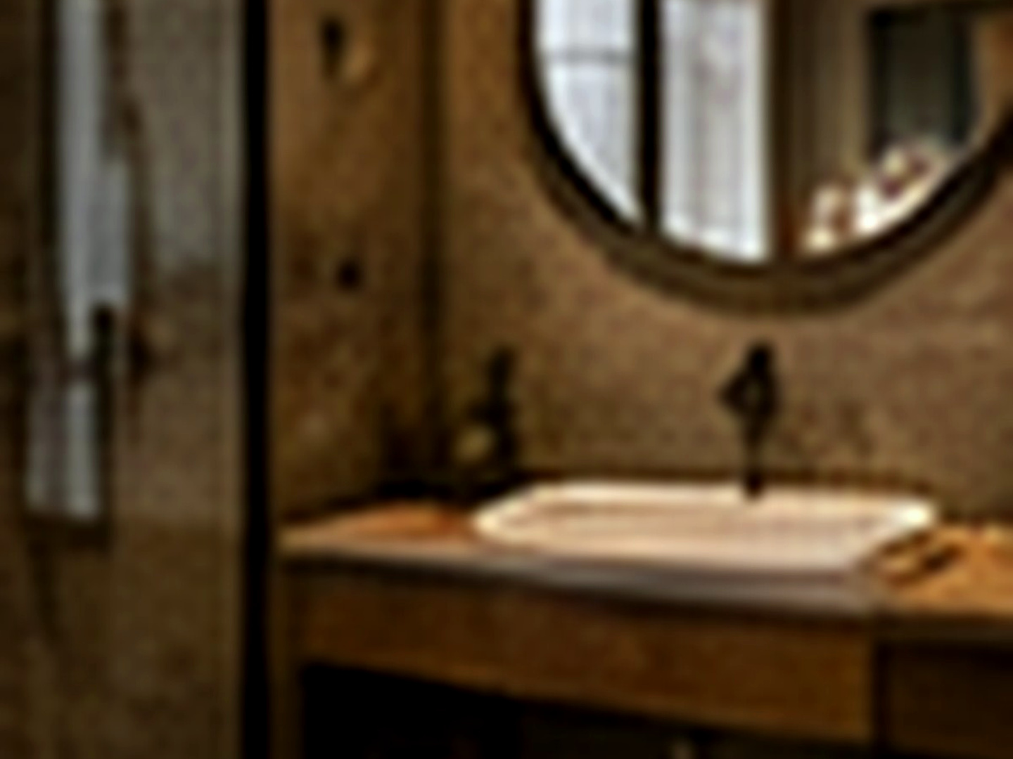 Deluxe Loft banyosunda geniş lavabo tezgâhı, yuvarlak ayna ve sıcak pirinç ayrıntılar